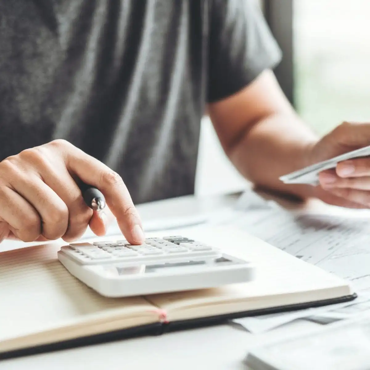 A person using a calculator to do paperwork.